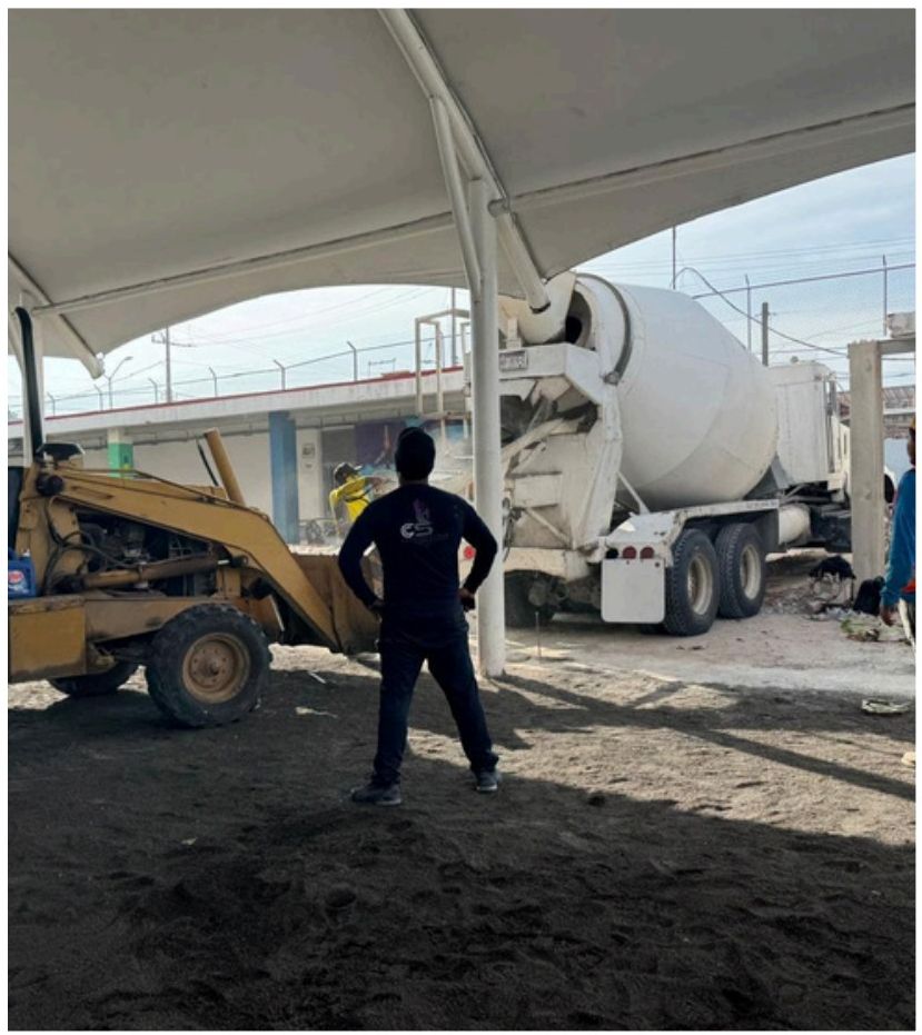 Maquinaria y personal esparciendo concreto en obra