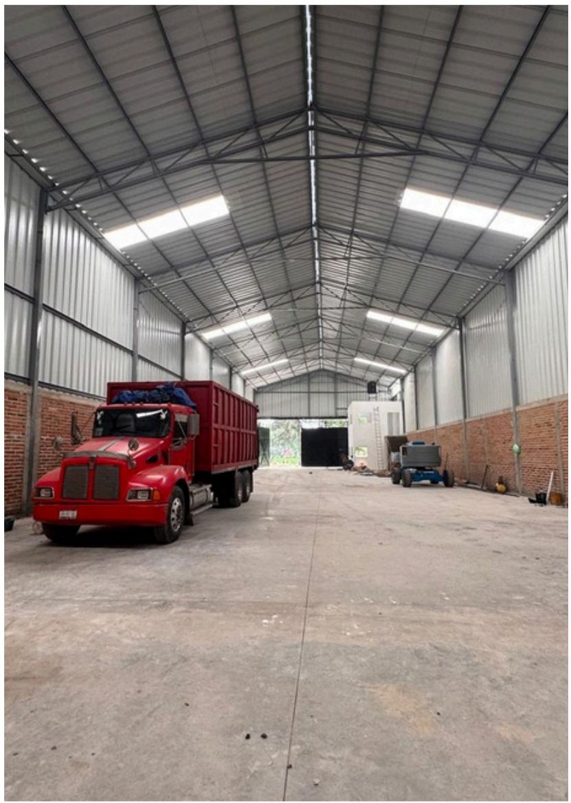 Interior de la bodega con camión rojo estacionado
