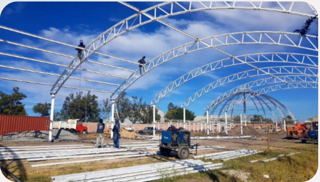 Trabajadores montando la estructura del techado curvo