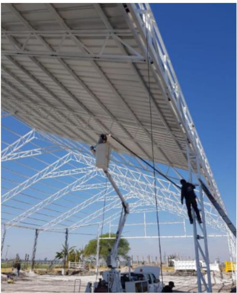 Trabajadores soldando la estructura metálica del almacén