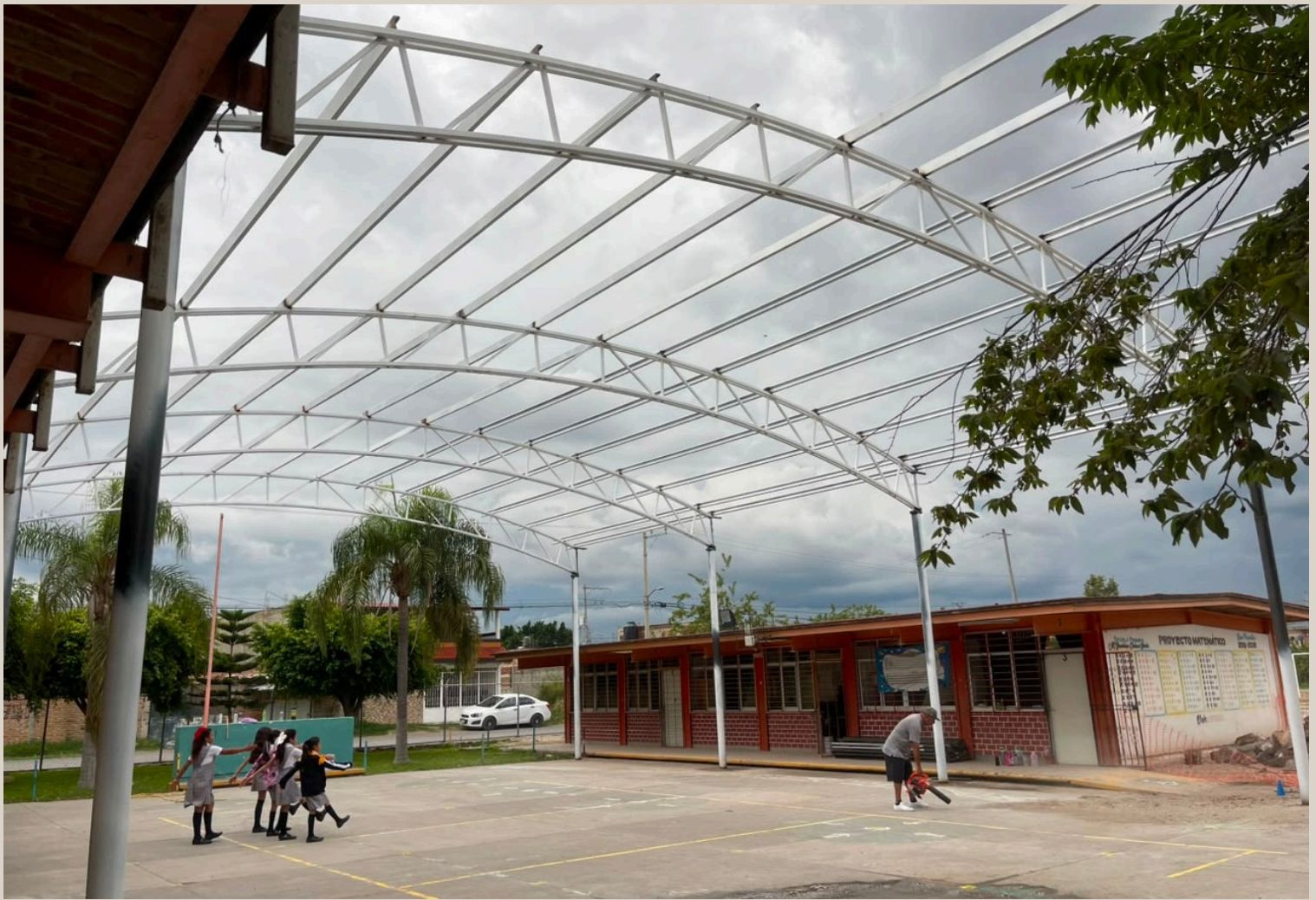 Alumnos en el patio bajo la techumbre metálica