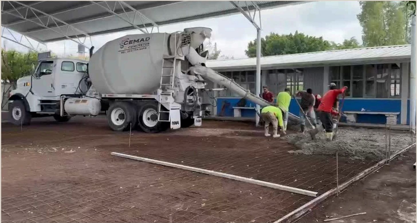 Camión revolvedora colando concreto hidráulico en la escuela