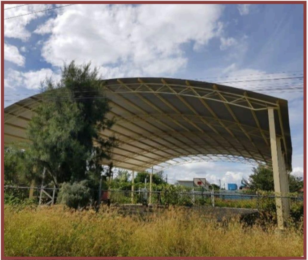 Vista exterior de la cancha con techado curvo